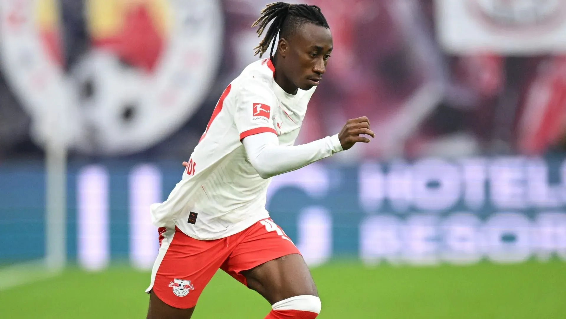 Yan Diomande usando camisa branca e calção vermelho em jogo do RB Leipzig. Jogador é alvo do Manchester United. Foto: Stuart Franklin/Getty Images