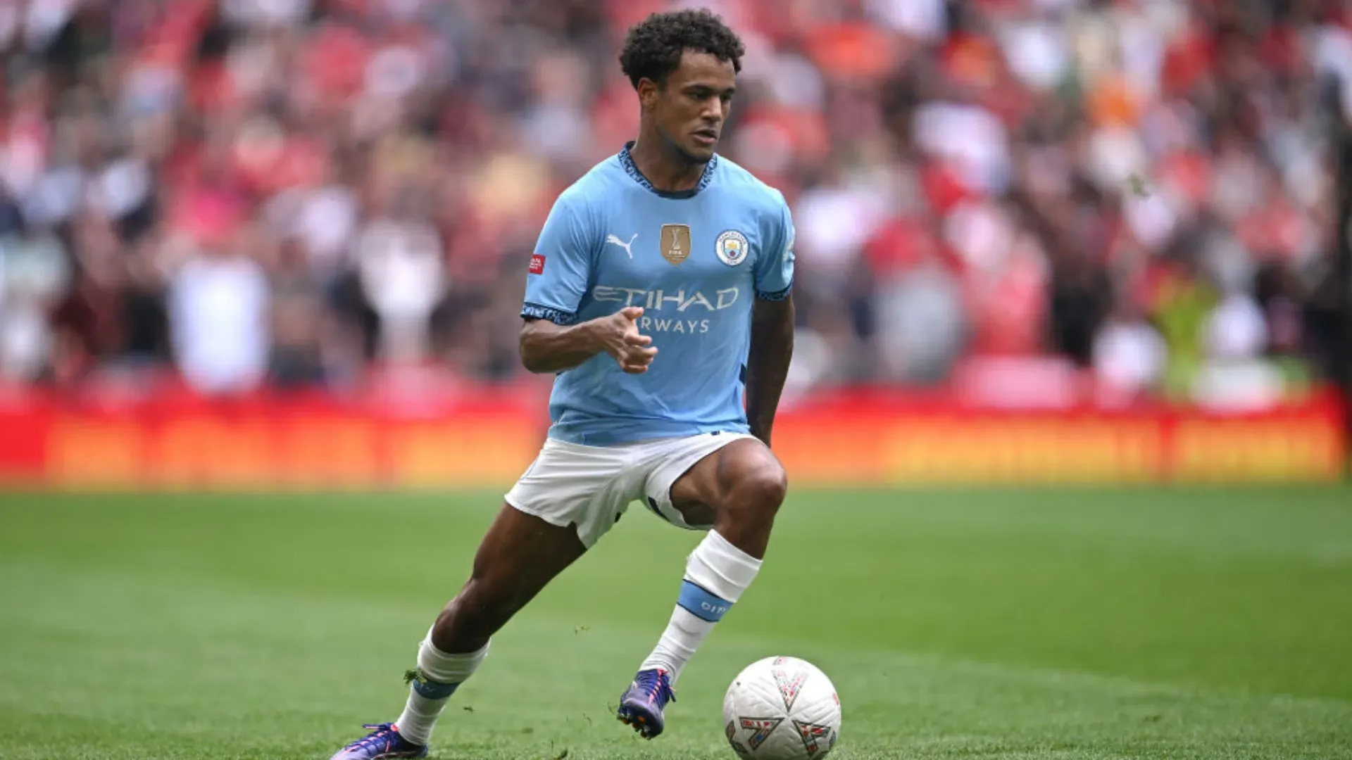 Oscar Bobb durante lance em jogo do Manchester City
