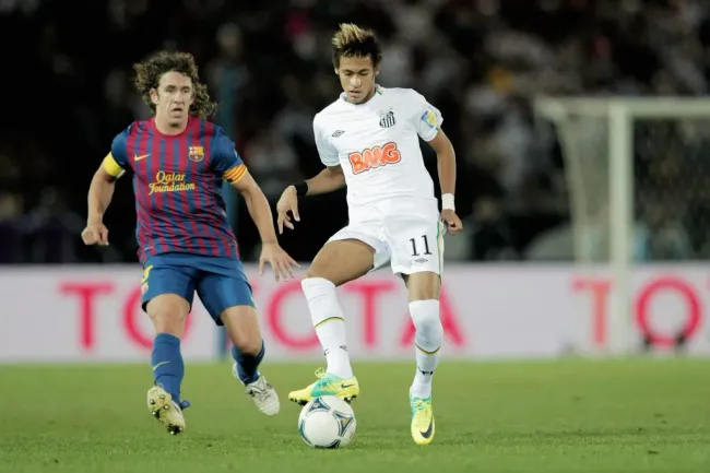 Neymar é marcado por Puyol em Santos x Barcelona, em 2011. Foto: Lintao Zhang/Getty Images.