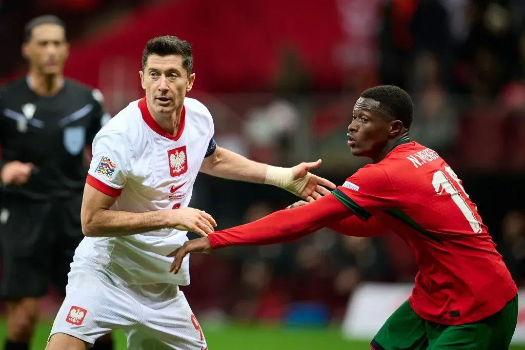 Lewandowski a disputar um lance como Nuno Mendes, lateral de Portugal. Foto: Rafal Oleksiewicz/Getty Images.