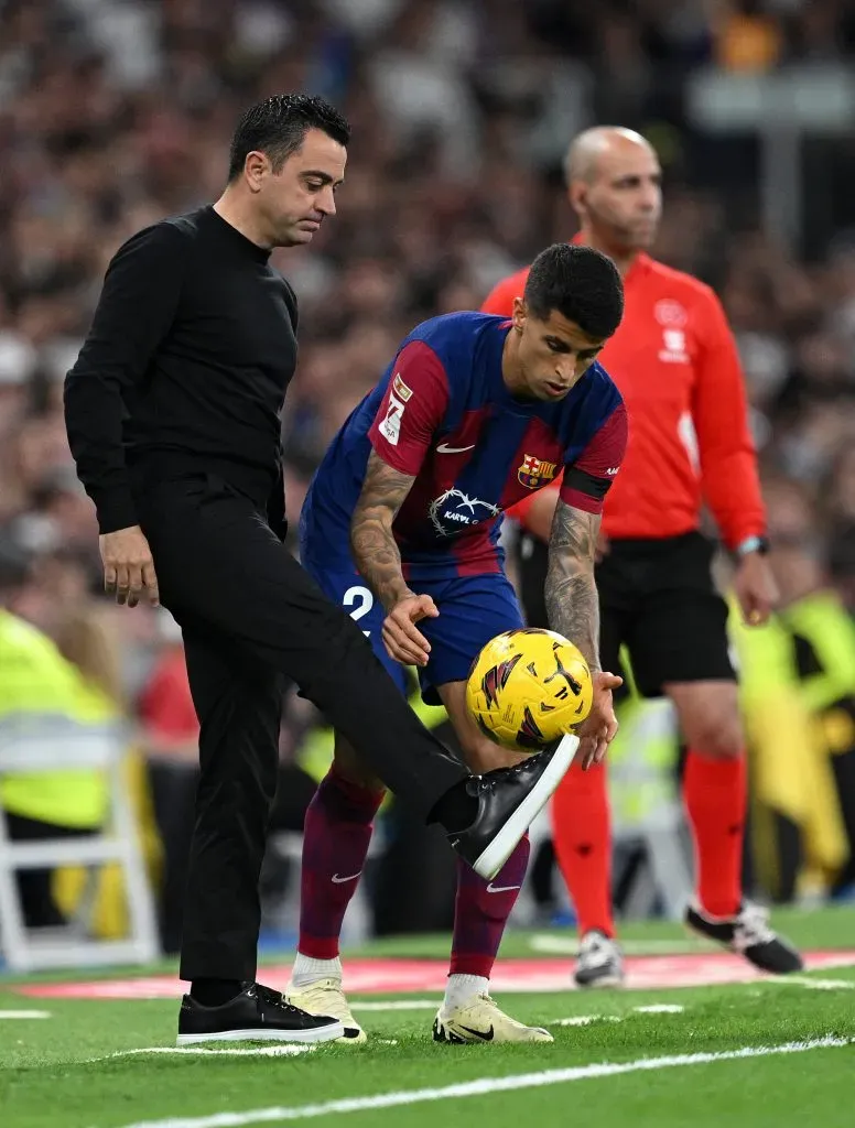 Xavi, enquanto treinador do Barcelona, junto de Cancelo, ex-jogador do clube. Foto: David Ramos/Getty Images.