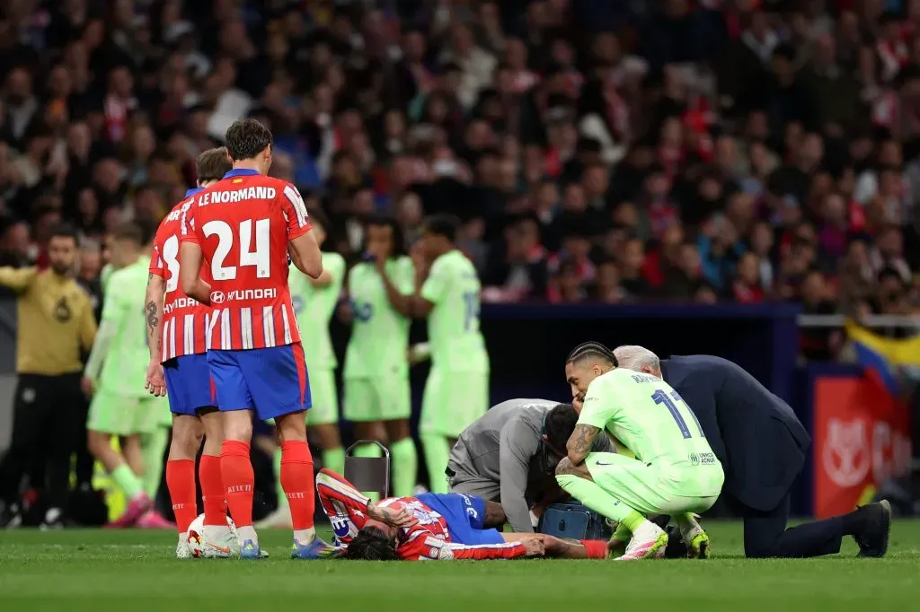 Raphinha observa De Paul, caído no relvado. Foto: Florencia Tan Jun/Getty Images.