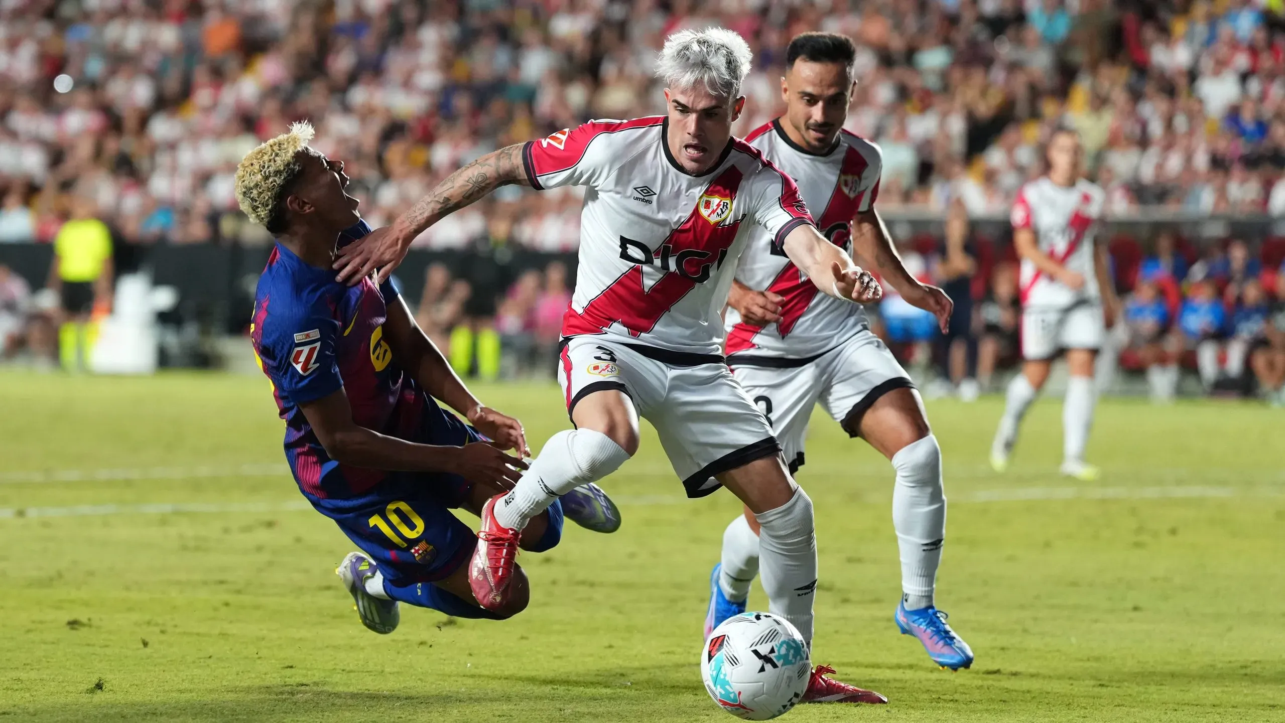 Lamine Yamal cai após disputa de bola com Pep Chavarria, do Rayo Vallecano. Foto: Angel Martinez/Getty Images