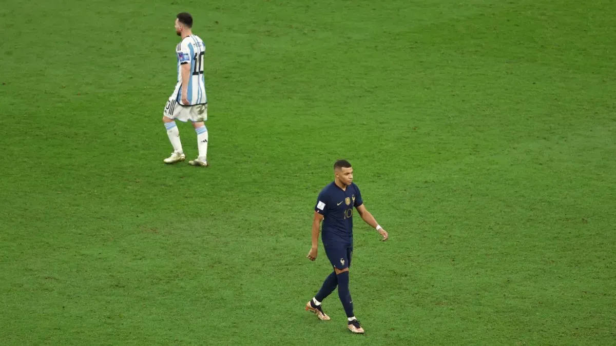 Kylian Mbappe of France celebrates scoring the team's first penalty in the penalty shoot out as Lionel Messi of Argentina prepares to take theirs.