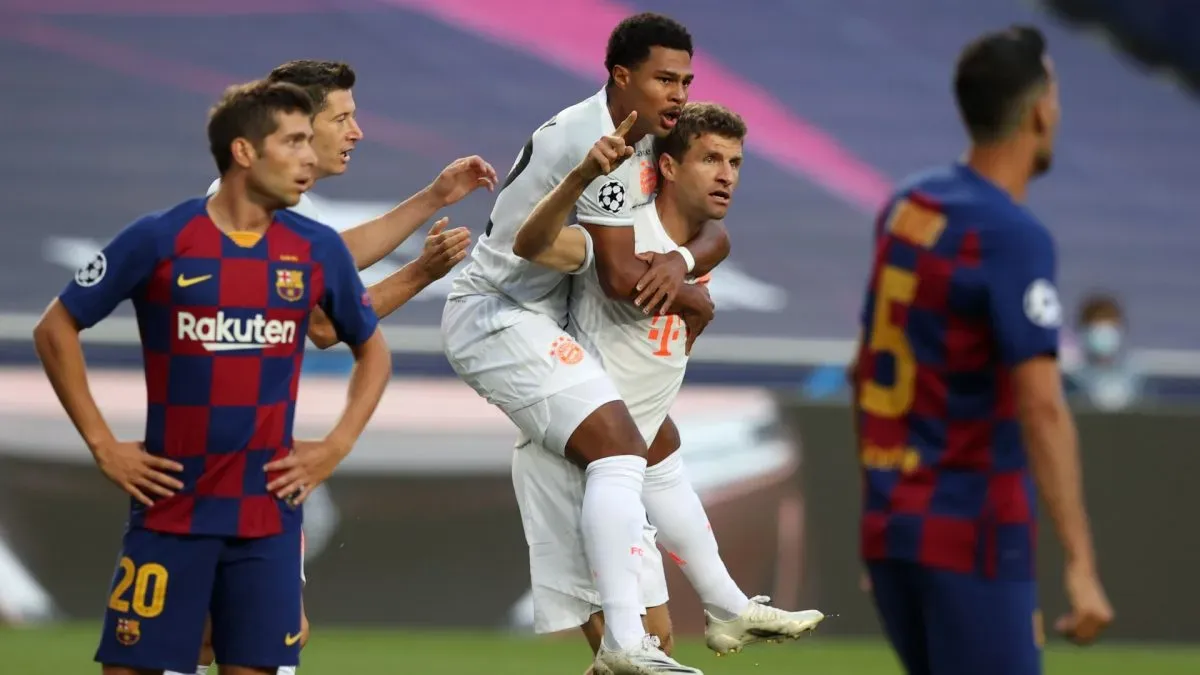 Thomas Mueller of FC Bayern Munich celebrates with teammate Serge Gnabry after scoring against FC Barcelona.