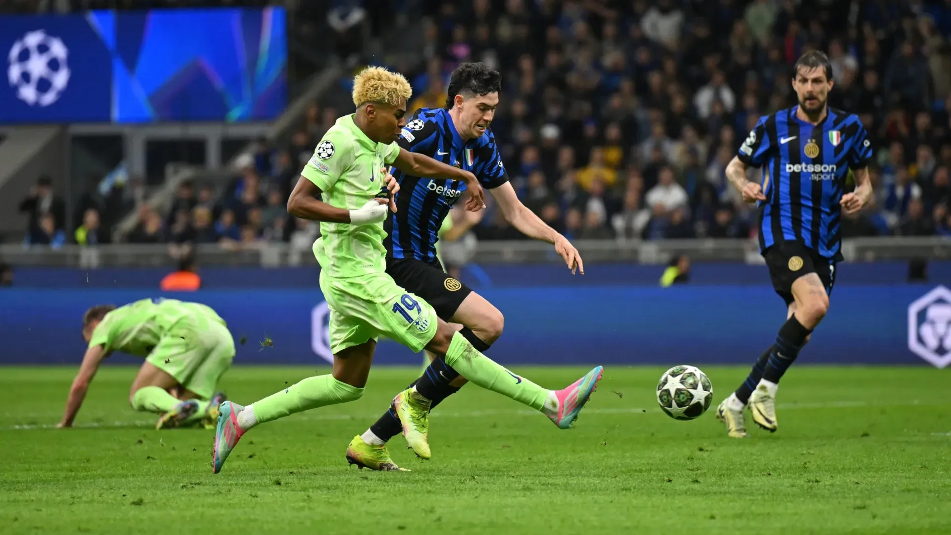 Lamine Yamal of FC Barcelona crosses the ball whilst under pressure from Alessandro Bastoni of FC Internazionale.
