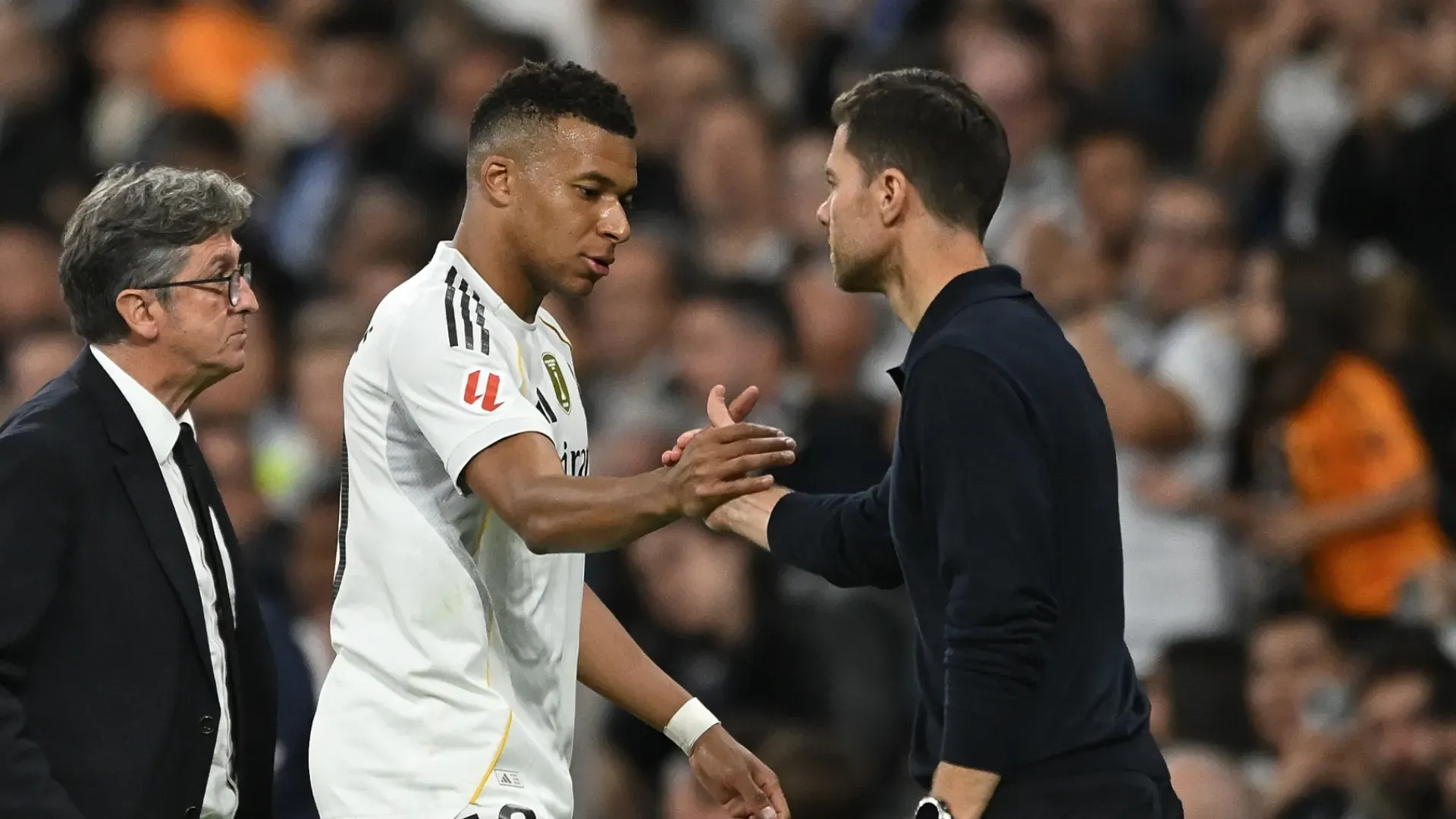 Kylian Mbappe of Real Madrid shakes hands with head coach Xabi Alonso.